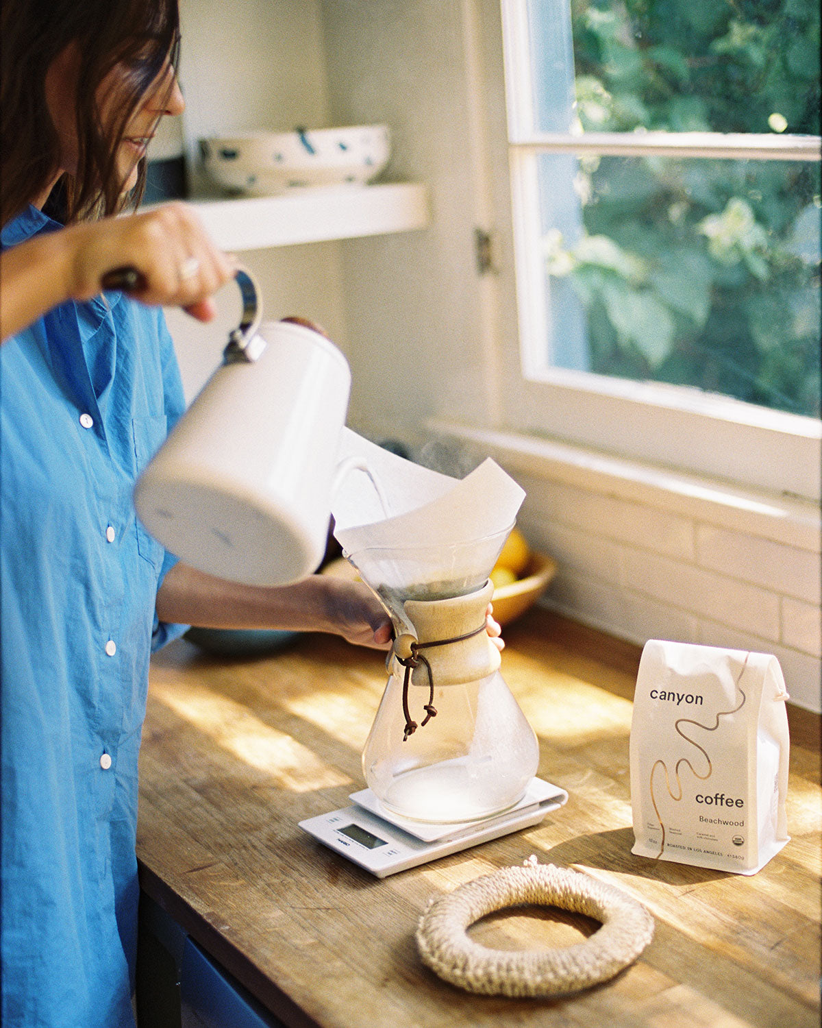 A white bag of Beachwood USDA organic coffee by Canyon Coffee in the kitchen with a chemex